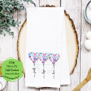 Pode incluir: Toalha de cozinha branca com tr&ecirc;s cora&ccedil;&otilde;es de aquarela, cada um com um esquema de cores diferente. Os cora&ccedil;&otilde;es est&atilde;o dispostos em fila e t&ecirc;m as palavras "f&eacute;", "esperan&ccedil;a" e "amor" escritas abaixo.