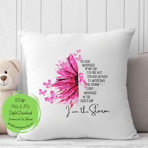 May include: A white pillow with a pink watercolor flower design and a pink ribbon. The text "The devil whispered in my ear you are not strong enough to withstand the storm today I whispered in the devil's ear I am the storm" is printed on the pillow.
