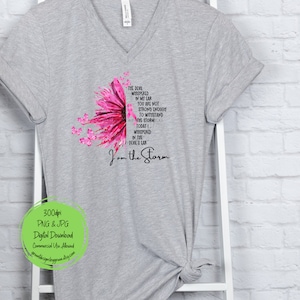 May include: A gray t-shirt with a pink sunflower design and the text "The devil whispered in my ear you are not strong enough to withstand the storm today I whispered in the devil's ear I am the storm".