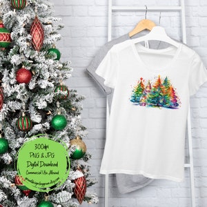 May include: A white t-shirt with a colorful watercolor design of Christmas trees. The trees are decorated with lights and ornaments. The text "300dpi PNG & JPG Digital Download Commercial Use Allowed" is on a green circle.