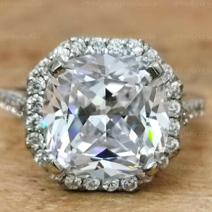 May include: A silver ring featuring a large, clear, cushion-cut gemstone encircled by a halo of smaller diamonds.