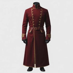 May include: A long, deep red coat featuring a high collar, double-breasted front with two rows of gold-toned buttons, and gold piping trim. The coat includes a matching belt at the waist and decorative gold-toned detailing on the sleeve cuffs.
