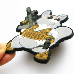 May include: A grey and white cartoon character wearing a tactical vest and holding a rifle. The character has large eyes and a fluffy tail. The vest is brown and has a pattern of small squares. The rifle is black and has a scope.