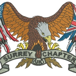 May include: An embroidered patch featuring a bald eagle with its wings spread, holding a tattered American flag on the left and a tattered Union Jack flag on the right. The eagle is perched on a banner that reads "SURREY CHAPTER UK".