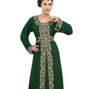 May include: A long, green dress with gold embroidery. The dress has a round neckline and long sleeves. The embroidery is on the neckline, sleeves, and hem of the dress.