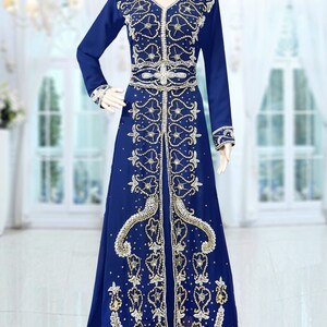 May include: A long, royal blue dress with intricate gold and white embroidery. The dress has a V-neckline and long sleeves. The embroidery features floral and paisley patterns.