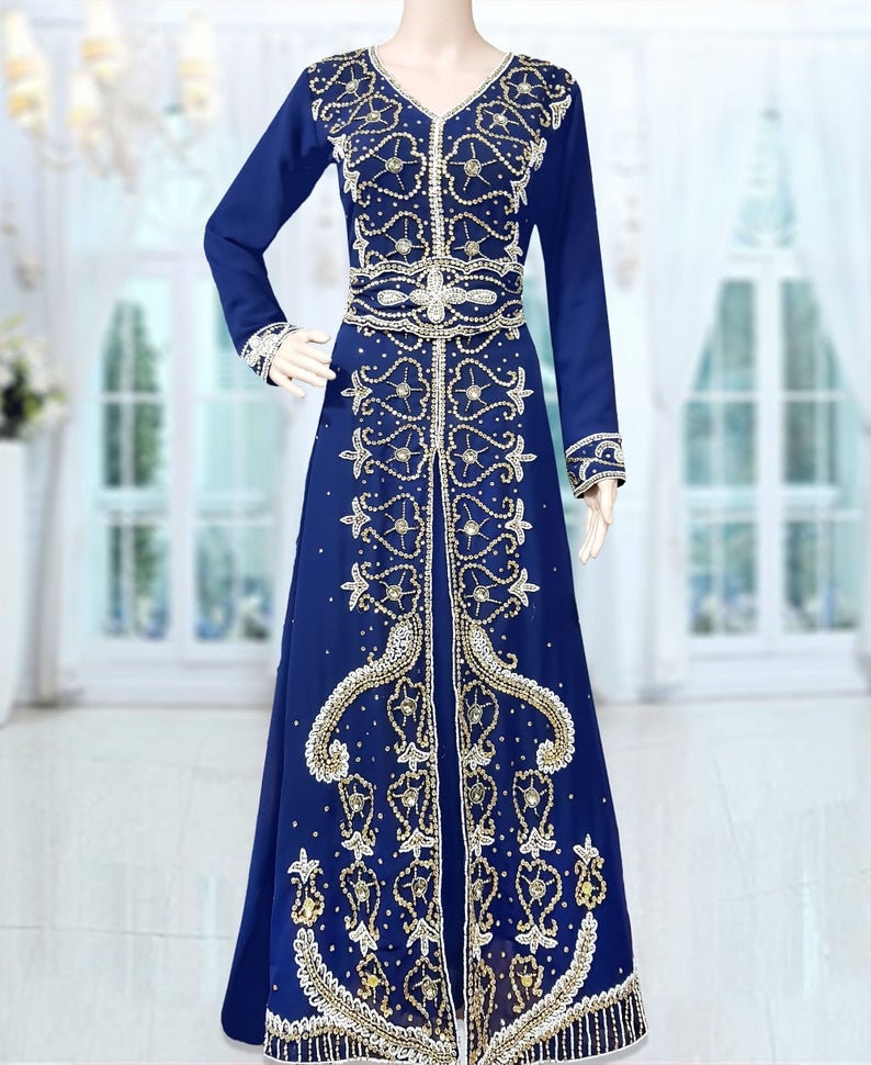 May include: A long, royal blue dress with intricate gold and white embroidery. The dress has a V-neckline and long sleeves. The embroidery features floral and paisley patterns.