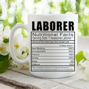 May include: White ceramic mug with a black and white graphic that reads "LABORER Nutritional Facts Serving Size: 1 Awesome Laborer* Amount Per Serving: One Great Job Hard Working 1000% Unrivaled Skill 500% Passion 100% Caring 100% Sleep 0% Caffeine 110% *Not a Significant Source of Gratitude Received. **Percent Daily Values are based on Your Unique Diet."