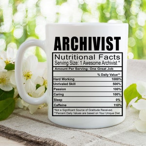Könnte beinhalten: Eine weiße Keramiktasse mit einer schwarzen Grafik, die "Archivist" lautet, und einem Nährwert-Etikett, das "Harte Arbeit", "Unübertroffene Fähigkeiten", "Leidenschaft", "Sorgfalt", "Schlaf" und "Koffein" mit Prozentangaben neben jedem Element auflistet.
