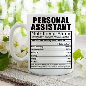 May include: White ceramic mug with a black graphic that reads "Personal Assistant" and a nutritional facts label with a humorous breakdown of the qualities of a personal assistant. The label includes categories like "Hard Working", "Unrivaled Skill", "Passion", "Caring", "Sleep", and "Caffeine".