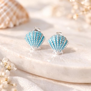 Brincos de prata esterlina com formato de concha e esmalte azul.