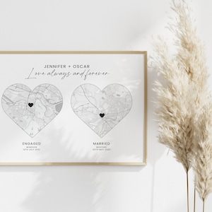 May include: A framed print with two heart-shaped map illustrations. The text reads "Jennifer + Oscar, Love always and forever." One heart is labeled "Engaged" with a date, the other "Married" with a date. The print is in black and white.