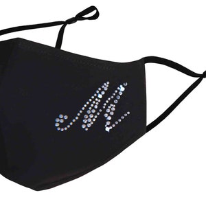 May include: Black face mask with a rhinestone letter M design.