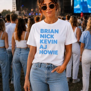 Könnte beinhalten: Ein weißes kurzärmeliges T-Shirt mit den Namen BRIAN, NICK, KEVIN, AJ und HOWIE, die in einer fetten, hellblauen serifenlosen Schrift auf der Brust gedruckt sind. Das T-Shirt wird mit einer hellblauen Jeans und einer dunklen Sonnenbrille kombiniert.