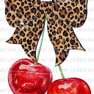 May include: Two red cherries with green stems and leaves. A leopard print bow is tied around the stems.