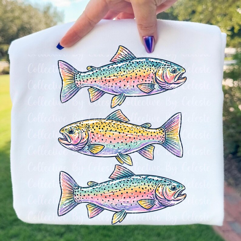 May include: White sweatshirt featuring three colorful rainbow trout illustrations. The fish are depicted with detailed scales and fins, showcasing a vibrant palette of blues, yellows, pinks, and greens. The design is a whimsical representation of aquatic life.