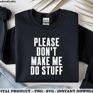 May include: Black sweatshirt with the text "PLEASE DON'T MAKE ME DO STUFF" in white block letters. The Gildan brand label is visible. The sweatshirt is folded, with a pair of jeans visible in the background.