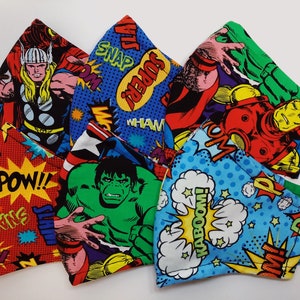 May include: Five colorful fabric face masks featuring comic book characters and phrases like "POW!" and "KABOOM!" The masks feature characters like Thor, Hulk, and Iron Man.
