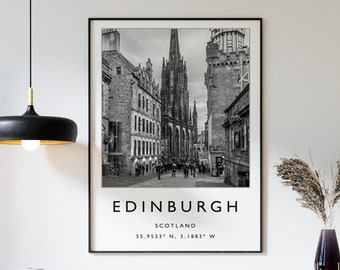 May include: Black and white photograph of Edinburgh, Scotland. The image shows a street lined with buildings, with a tall church spire in the center. The text "EDINBURGH" is printed below the image, along with the coordinates "55.9533° N, 3.1883° W".