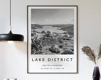 May include: Black and white photograph of a lake and mountains with the text "LAKE DISTRICT" and "UNITED KINGDOM" below the image. The coordinates "54.3719° N, 2.9376° W" are listed below the text.