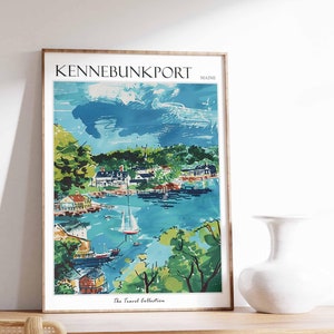 May include: A framed art print of Kennebunkport, Maine, featuring a watercolor-style depiction of a coastal town with boats on the water. The print has a wooden frame and includes the text "Kennebunkport" and "Maine". The Travel Collection is also printed at the bottom.