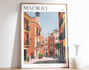 May include: A colorful illustration of a street scene in Madrid, Spain. The image features a narrow street lined with buildings in shades of orange, yellow, and red. The text "MADRID" and "SPAIN" are at the top of the image, and "The Travel Collection" is at the bottom.
