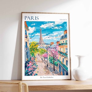 May include: A framed illustration of the Eiffel Tower in Paris, France. The illustration is in a colorful, painterly style and shows a street scene with buildings and trees. The text "PARIS" and "FRANCE" are at the top of the illustration, and "The Travel Collection" is at the bottom.