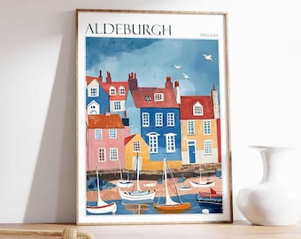 May include: A colorful illustration of a seaside town with boats in the harbor. The print features a blue sky with white birds flying overhead. The text "ALDEBURGH ENGLAND" is at the top of the print.
