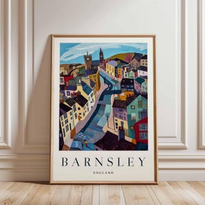 Puede incluir: L&aacute;mina art&iacute;stica enmarcada de Barnsley, Inglaterra, con una representaci&oacute;n colorida y estilizada de un paisaje urbano. La obra muestra edificios de varios colores, una torre de iglesia y el texto "BARNSLEY ENGLAND" en la parte inferior.