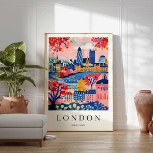 Peut inclure: Une illustration color&eacute;e de l'horizon de Londres avec le texte "LONDON ENGLAND" en bas. L'illustration repr&eacute;sente des b&acirc;timents, une rivi&egrave;re et des arbres dans des tons de rose, bleu, jaune et vert.
