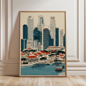 Op de afbeelding: Een ingelijste kunstdruk met een stadsgezicht met hoge wolkenkrabbers in blauw en wit. De voorgrond toont gebouwen met rode daken en een waterpartij met boten. Het kunstwerk heeft een vintage stijl, geïnspireerd op reisposters.