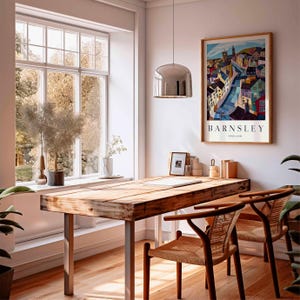 Puede incluir: Una habitaci&oacute;n luminosa con un escritorio de madera y dos sillas. Un p&oacute;ster enmarcado de Barnsley, Inglaterra, cuelga de la pared. Una gran ventana ofrece vistas a los &aacute;rboles. Una l&aacute;mpara colgante plateada cuelga sobre el escritorio.