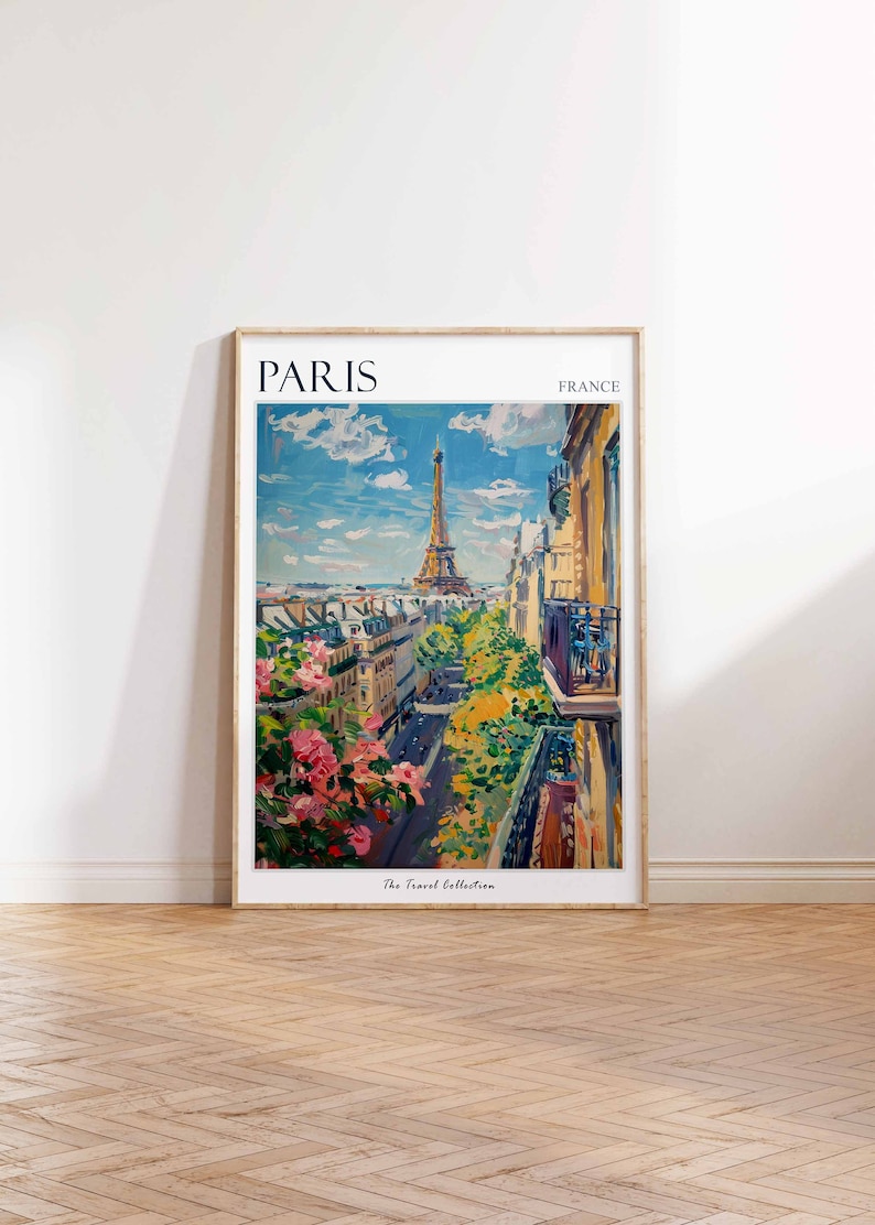 Pode incluir: Uma impress&atilde;o emoldurada de uma pintura colorida que retrata uma vista da Torre Eiffel em Paris, Fran&ccedil;a. A pintura mostra uma rua ladeada por edif&iacute;cios e &aacute;rvores, com a Torre Eiffel ao fundo. O texto "PARIS" e "FRANCE" est&aacute; impresso no topo da impress&atilde;o, e "The Travel Collection" est&aacute; impresso na parte inferior.