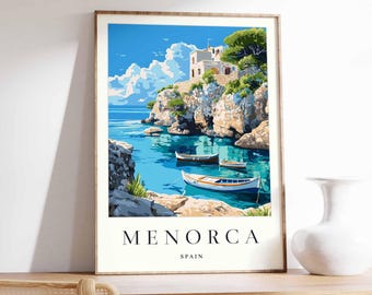 May include: Framed art print of Menorca, Spain. The artwork depicts a coastal scene with turquoise water, boats, and a white building on a cliff. The sky is blue with fluffy white clouds. The print is in a wooden frame.