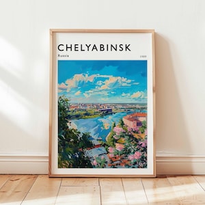 May include: A framed art print showing a colourful landscape painting of Chelyabinsk, Russia, from 1989. The artwork depicts a river flowing through a city with buildings and greenery under a bright blue sky with clouds. The print is in a wooden frame.