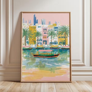 Könnte beinhalten: Ein gerahmter Kunstdruck, der eine farbenfrohe Stadtlandschaft mit Booten auf dem Wasser zeigt. Die Gebäude sind in Gelb, Rosa und Weiß gemalt, mit Palmen und einem rosa Himmel. Die Boote haben rosa Markisen.