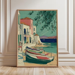 May include: A framed art print showing a coastal scene with colourful buildings and boats. The artwork features a teal sky, turquoise water, and a sandy shore. The buildings have pink, white, and green accents. Several boats are docked along the shore.