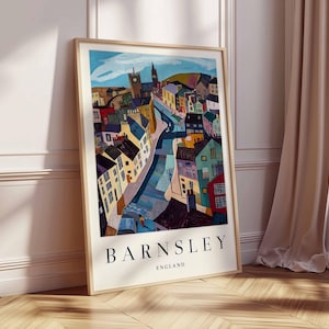 Puede incluir: Una impresi&oacute;n art&iacute;stica enmarcada que muestra una representaci&oacute;n colorida y estilizada de Barnsley, Inglaterra. La obra de arte presenta edificios de varios colores, con el nombre de la ciudad, BARNSLEY, y el pa&iacute;s, ENGLAND, impresos en la parte inferior. La impresi&oacute;n se exhibe contra una pared blanca y un suelo de madera.