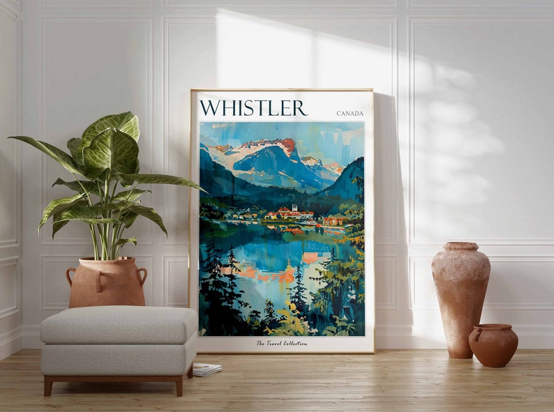 May include: A vintage travel poster with a blue and green mountain landscape reflected in a lake. The poster is framed in gold and has the text "WHISTLER CANADA" at the top. The text "The Travel Collection" is at the bottom.