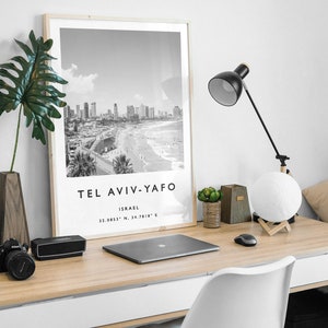 May include: Black and white photograph of Tel Aviv-Yafo, Israel, with the city skyline and beach in the background. The text "Tel Aviv-Yafo" and "Israel" is printed below the image, along with the coordinates "32.0853&deg; N, 34.7818&deg; E".