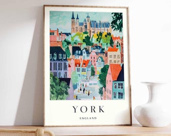 May include: A framed art print featuring a colorful illustration of York, England. The artwork depicts a cityscape with buildings in shades of pink, blue, and orange, with the word "YORK" and "ENGLAND" printed at the bottom.