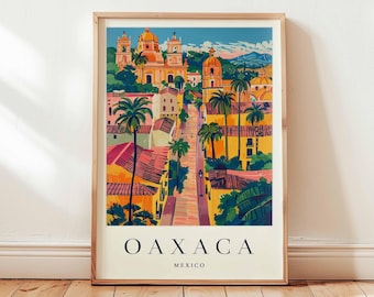 Op de afbeelding: Een ingelijste kunstdruk met een kleurrijke illustratie van Oaxaca, Mexico. Het kunstwerk toont een straatbeeld met gebouwen, palmbomen en een kerk. Het woord "OAXACA" is gedrukt in grote, zwarte letters, met "MEXICO" eronder.