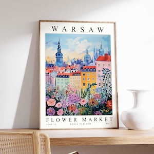 May include: A framed art print depicting Warsaw, Poland, with the word "WARSAW" at the top. The image shows a flower market with colourful flowers and buildings. Text at the bottom reads "FLOWER MARKET, JUNE 15, WORLD IN BLOOM, NO. 7."