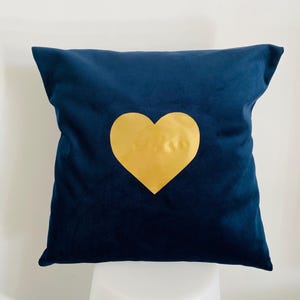 Peut inclure: Un coussin bleu marine avec un motif de cœur doré.