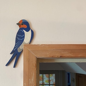 Hand painted swallow for sitting on a door frame.