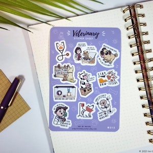 May include: A sticker sheet with a purple background featuring a variety of veterinary-themed illustrations. The stickers include a stethoscope, a veterinarian, a dog, a cow, a sheep, and a variety of text-based stickers. The text on the stickers includes "Buy One Get One Free", "Bread in Captivity", "Stay Paw-sitive", "What is Love?", and "Baby Don't Herd Me!"