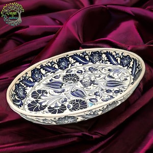May include: An oval ceramic serving tray with a white background and blue and white floral pattern. The tray is hand-painted with intricate details.