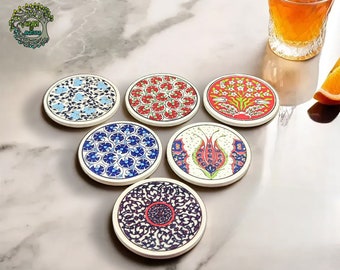 May include: Set of six round ceramic coasters with colorful floral and geometric patterns. Each coaster features a unique design in shades of blue, red, and green, with a cream-colored border. Perfect for protecting surfaces from drink condensation.