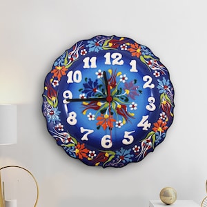 May include: A blue and white ceramic wall clock with a floral design. The clock has black hands and white numbers.