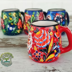 Puede incluir: Cuatro tazas de café turco con diseños florales. Las tazas están hechas de cerámica y tienen un aspecto tradicional. Las tazas son de diferentes colores, incluyendo rojo, azul y verde.